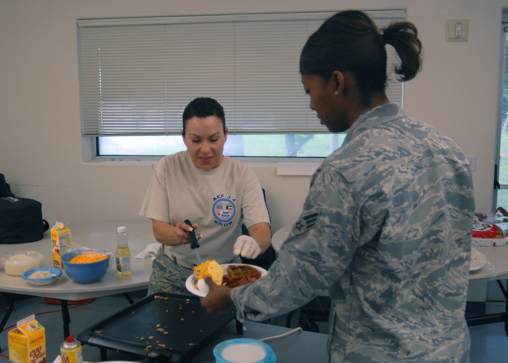 Staff Sgt. Marina Boulos, 95th Aerospace Medical Squadron non-commissioned officer in charge of community health, serves Senior Airman Jervinia Thomas, 95th Comptroller Squadron financial management technician an omlett during the Dorm Dwellers Breakfast at the Chapel 1 annex April 21. Dorm dinners or breakfasts are held every two months to offer a healthy meal to dorm dwellers, this breakfast was hosted by the Air Force Sergeants Assocation. (U.S. Air Force photo/Airman 1st Class William O'Brien)