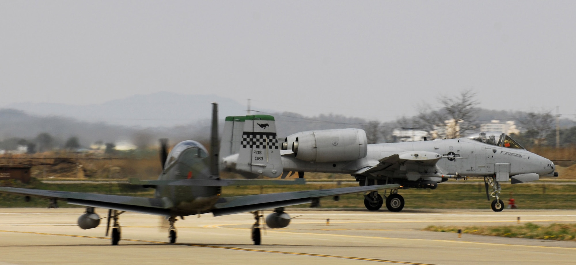 An A-10 Thunderbolt II takes off past a South Korean air force KA-1 during the Buddy Wing Program April 14 at Osan Air Base, South Korea. The 51st Fighter Wing hosted a combined exchange exercise with the participation from the 25th Fighter Squadron here and South Korean air force's 15th Composite Wing from Seoul Air Base. (U.S. Air Force photo/Senior Airman Stephenie Wade)