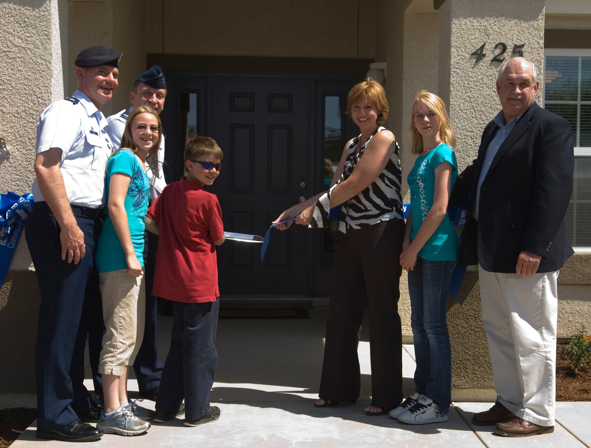 VANDENBERG AIR FORCE BASE, Calif. --   Lt. Col. Joseph Milner, 30th Security Forces commander, alongside his family and 30th Space Wing Commander Col. David Buck, cuts the ribbon symbolizing the opening of the Milner's new home and the first home to be opened in the new company and field grade housing complex here. The Milner's home is part of a project that encompasses 458 acres with plans to build 164 new homes and renovate 703 of the existing homes.  (U.S. Air Force photo/Airman 1st Class Andrew Lee)