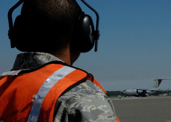 Staff Sgt. John Green watches as Maj. Gen. Erwin F. "Erv" Lessel III taxis in the newest C-17 addition to Charleston AFB April 17. This is the seventh out of ten new C-17s Charleston AFB will receive. General Lessel is the Director of Plans, Programs, Requirements and Assessments, and the Director of the San Antonio Joint Program Office, Headquarters Air Education and Training Command, Randolph AFB, Texas. Sergeant Green is a crew chief with the 437th Aircraft Maintenance Squadron. (U.S. Air Force photo/Senior Airman Katie Gieratz)