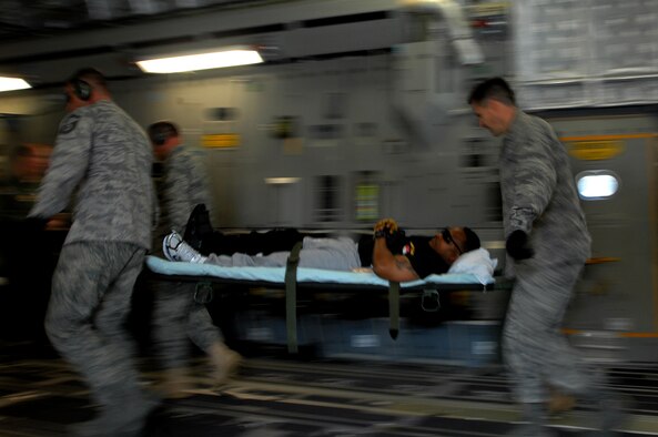 Air Force members from the 435th Aeromedical Squadron load wounded military members returning from the Area of Operation onto a C-17 Globemaster III for transport back to the continental United States for further treatment. Members of the 86th Aeromedical Evacuation Squadron provided patient care for the duration of the flight. (U.S. Air Force photo by Airman 1st Class Kenny Holston)
