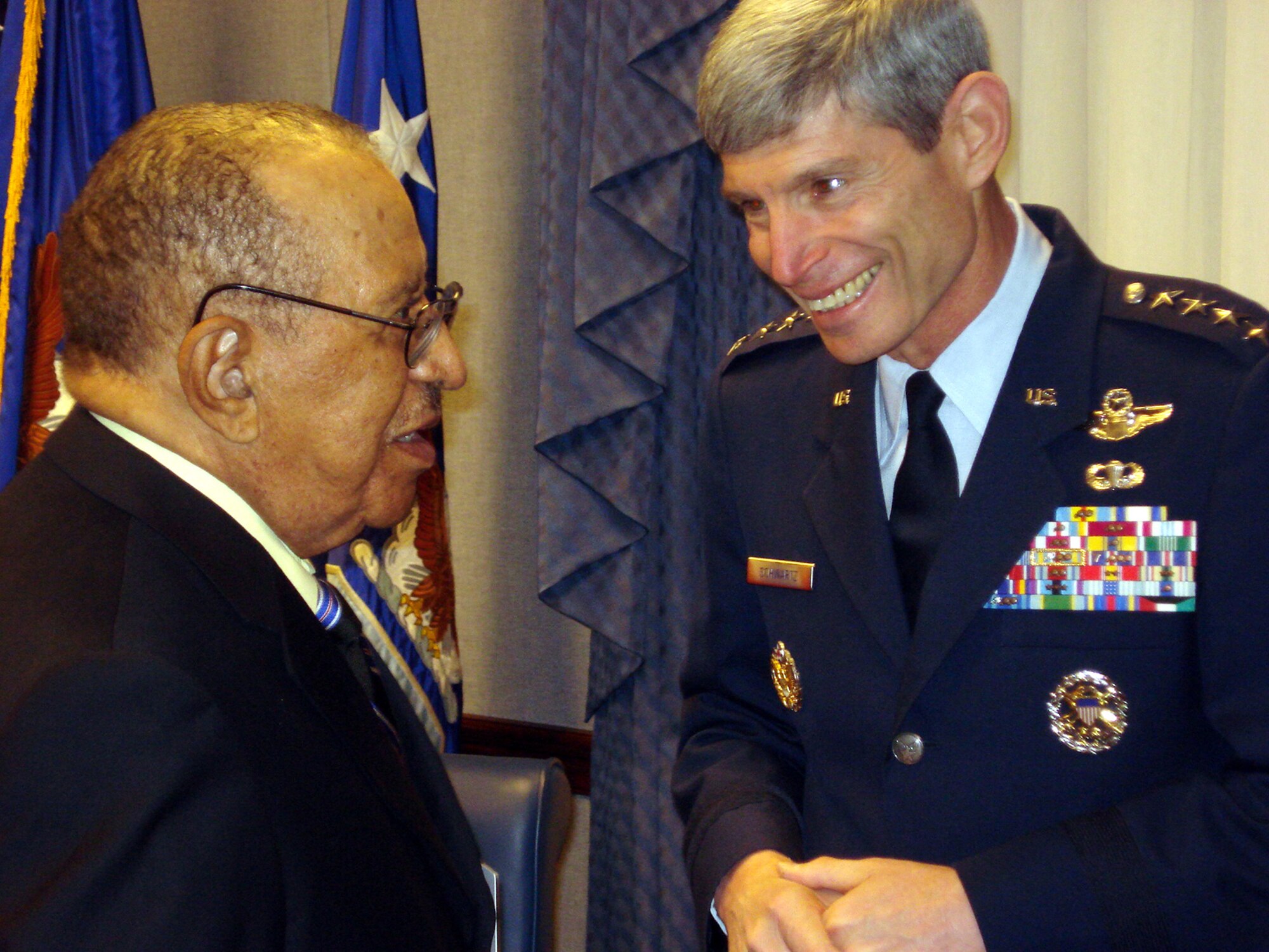 Chief of Staff of the Air Force, Norton A. Schwartz, and Lt. Col. (ret.) James Warren, an original Tuskegee Airman, chat in the commander's conference room before the general gave the Airmen a briefing on his top priorities. The four Tuskegee Airmen departed for a visit with U.S., and coalition forces in the area of responsibility on April 20, 2009. (U.S. Air Force photo/Maj. Andra P. Higgs)