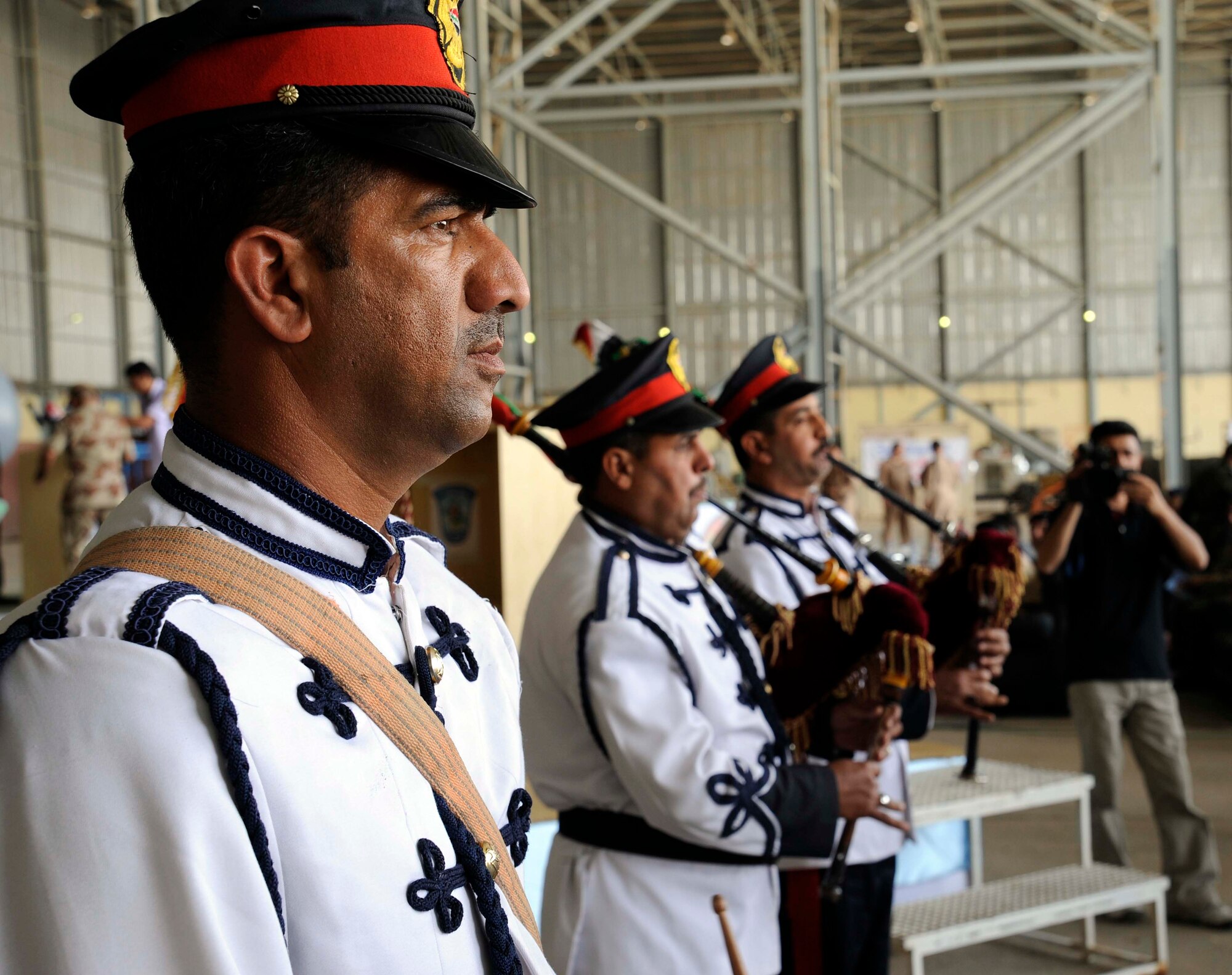 U.S. Air Force Airmen and Iraqi military members listen while an Iraqi air force band plays for the crowd at the 78th annual Iraqi Air Day at New al-Muthana Air Base, Iraq April 22, 2009.  With a multitude of people in attendance, Iraqi officials, to include the Iraqi minister of defense and the Iraqi air force chief of staff, spoke to the crowd on how far the Iraqi air force has come in the past few years.  There were also static displays of the Iraqi aircraft on display for people to look at before and after the official ceremony. (U.S. Air Force photo by: Senior Airman Jacqueline Romero)