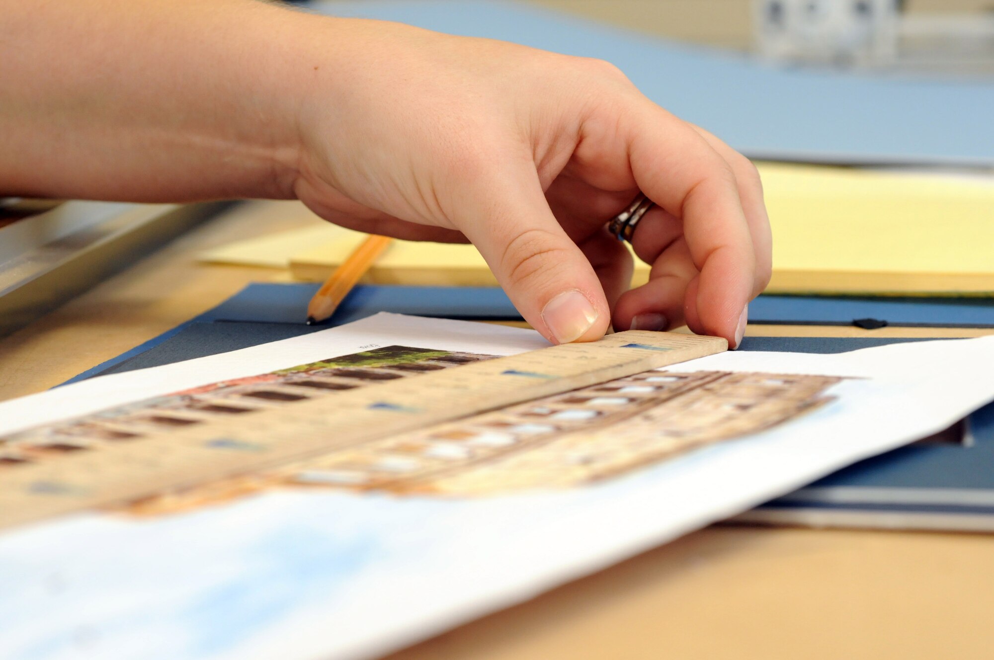 Jessica Littledale, 100th Force Support Squadron sales clerk, takes measurements for a print she is preparing to frame at the RAF Mildenhall frame shop.  The frame shop can put anything in a frame, from paintings and posters to fabric or even baseball gloves.  (U.S. Air Force photo by Staff Sgt. Austin M. May)