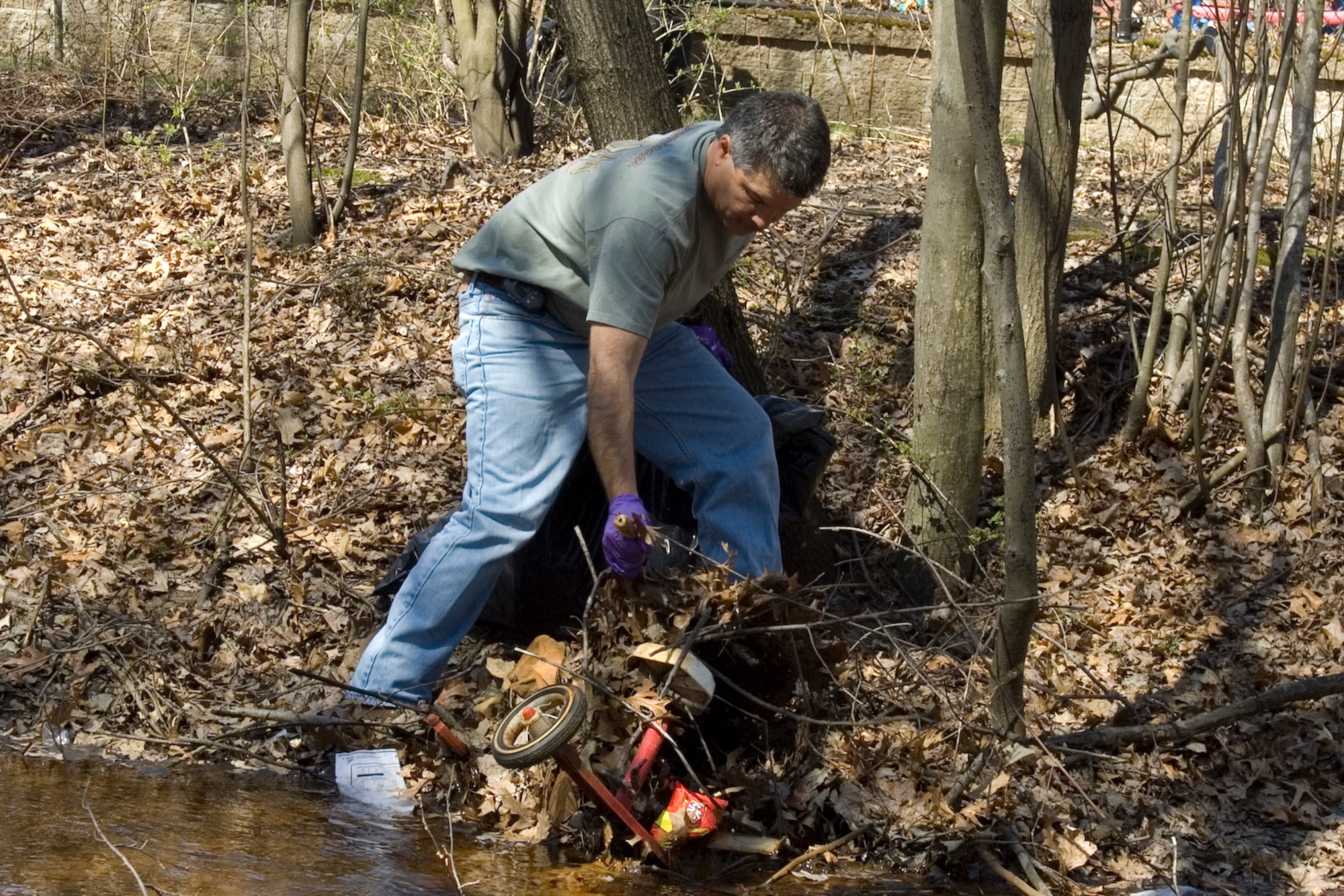 HANSCOM AIR FORCE BASE, Mass. –A volunteer pulls a tricycle out of the bank of the Shawsheen River during the base’s Earth Day clean up event April 17. Volunteers from across the base took part in cleaning up Hanscom’s wetland and Shawsheen River areas. (U.S. Air Force photo by Rick Berry)