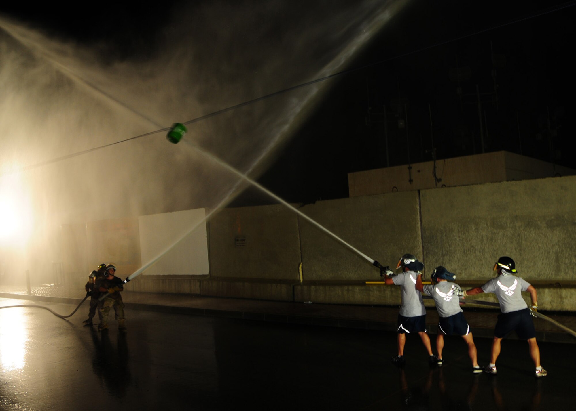 SOUTHWEST ASIA -- Off-duty firefighters, 386th Expeditionary Civil Engineer Squadron, compete in a water fight against on-duty firefighters, 386th ECES, to spray a five gallon barrel, suspended on a rope at 15-20 feet,  across a certain point on the rope during the Firefighter Challenge, April 19. During the single elimination challenge the participants were required to wear a helmet with face shield and gloves for safety purposes. (U.S. Air Force photo/ Senior Airman Courtney Richardson)
