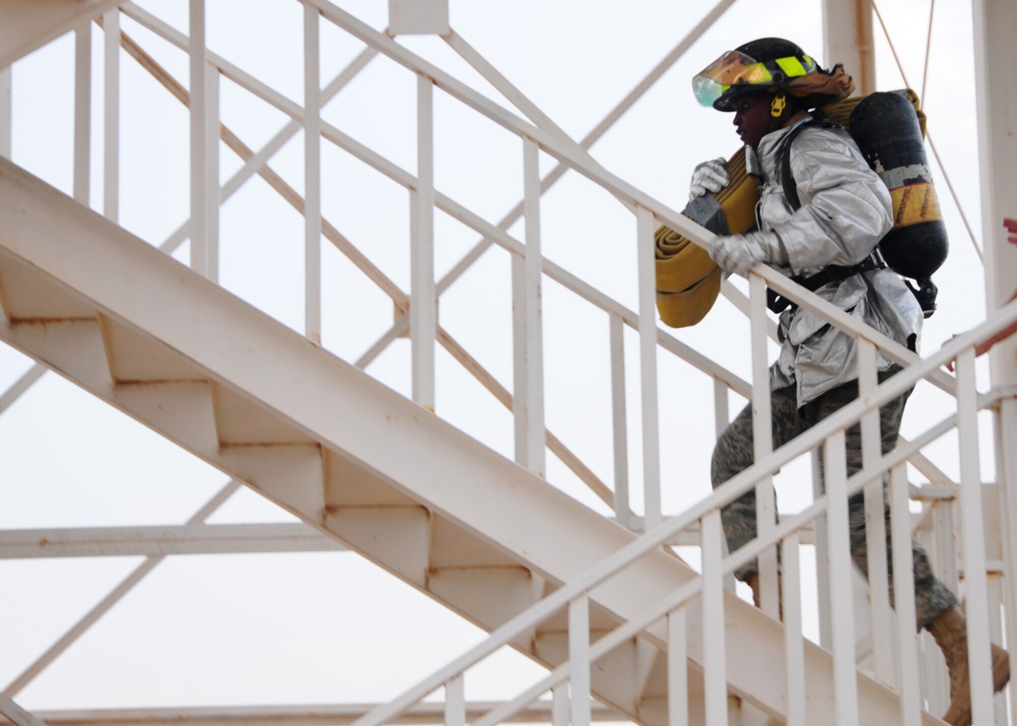 SOUTHWEST ASIA -- Col. Marcia Meeks-Eure, 386th Expeditionary Mission Support Group commander, races up a flight of stairs with a hotel pack during the Firefighter Challenge at an air base in Southwest Asia, April 19. During the challenge the participants were required to climb the tower, unload the hotel pack at the top, and another teammate hoisted a hose roll to the top of the tower before advancing to the next station. Colonel Meeks-Eure is originally from Alexandria, La. (U.S. Air Force photo/ Senior Airman Courtney Richardson) 