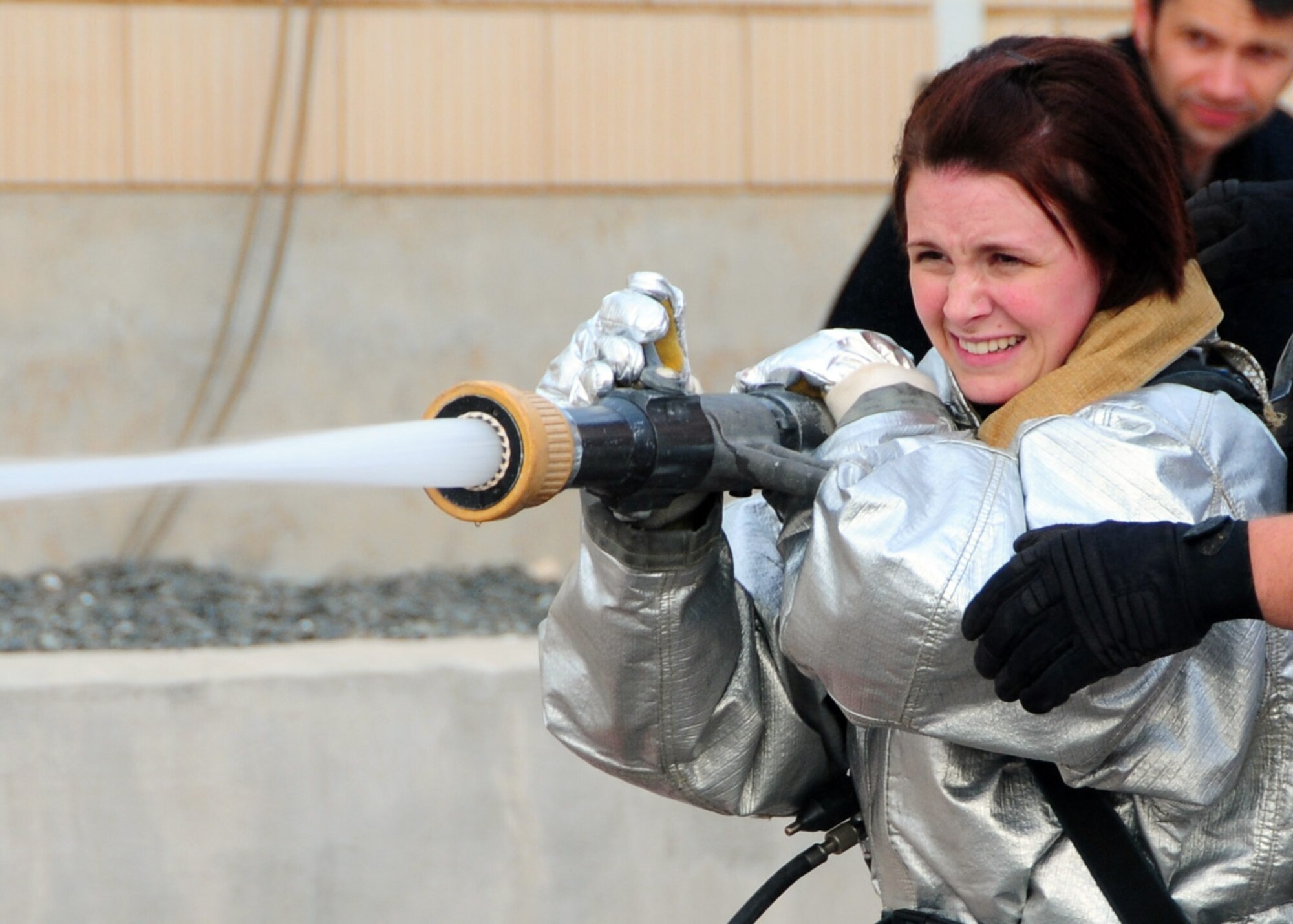 SOUTHWEST ASIA -- Senior Airman Susan Sayas, 386th Expeditionary Logistics Readiness Squadron, charges a fire hose during the Firefighter Challenge at an air base in Southwest Asia, April 19. The challenge consisted of 386th Air Expeditionary Wing members in teams of three completing six stations in the lowest time. Airman Sayas is currently deployed from Nellis Air Force Base, Nev., and is originally from St. Louis. (U.S. Air Force photo/ Senior Airman Courtney Richardson)