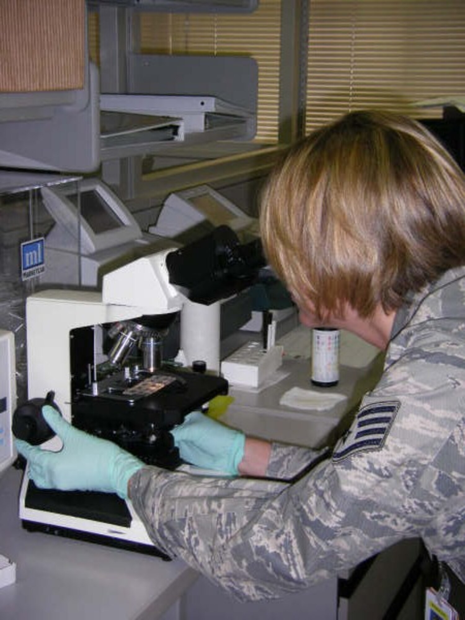 U.S. Air Force Staff Sgt. Jennifer Attridge, a Labratory Techneician with the 18th Medical Operations Squadron, looks for abnormalities while performing a microscopic examination of a urine sample. (Courtesy Photo)