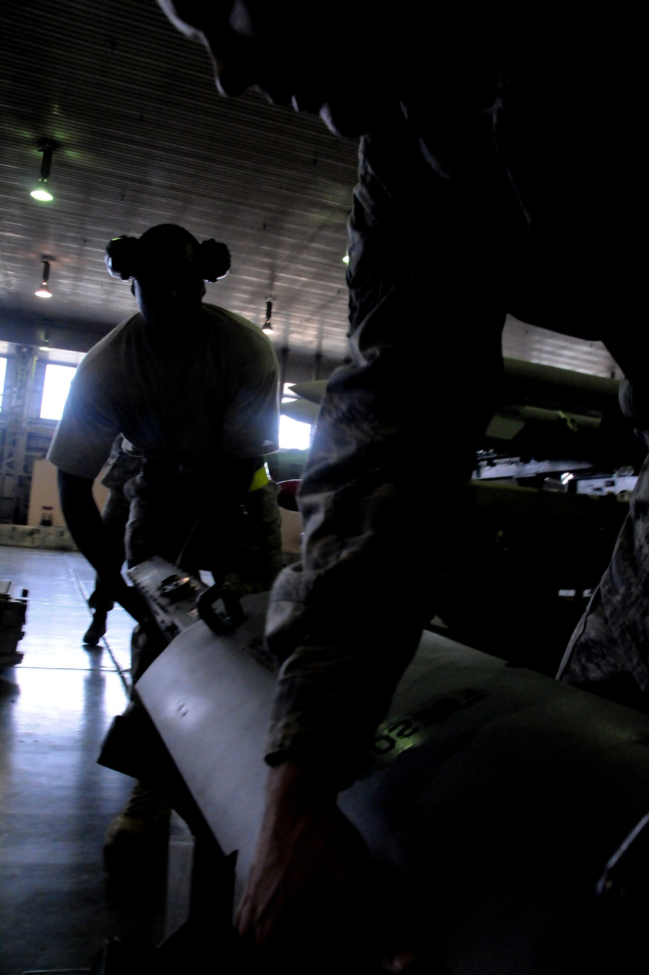 MISAWA AIR BASE, Japan -- Staff Sgt. Marcus Smith and Senior Airman Patrick Cannon, 35th Aircraft Maintenance Squadron weapons-load crew members, prepare a munition for loading during a weapons-load competition April 10, 2009. The team's time will be judged against a load crew downrange.  (U.S. Air Force photo by Senior Airman Jamal D. Sutter)