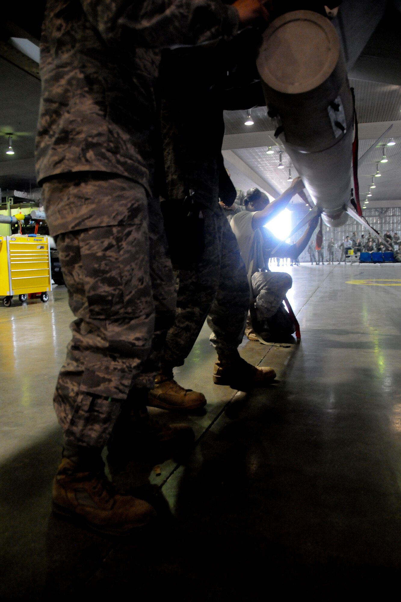 MISAWA AIR BASE, Japan -- Staff Sgt. Marcus Smith, 35th Aircraft Maintenance Squadron, along with his weapons-load crew members, performs finishing touches on a munition during a weapons-load competition April 10, 2009. Sergeant Smith’s primary job during the competition was to run the checklist and ensure the load went smoothly. (U.S. Air Force photo by Senior Airman Jamal D. Sutter)