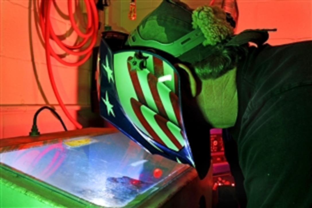 Randy Cherland, a metals technician with the U.S. Air Force 57th Components Maintenance Squadron, uses a purge chamber to weld a jet engine augmenter nozzle support on Nellis Air Force Base, Nev., April 16, 2009.