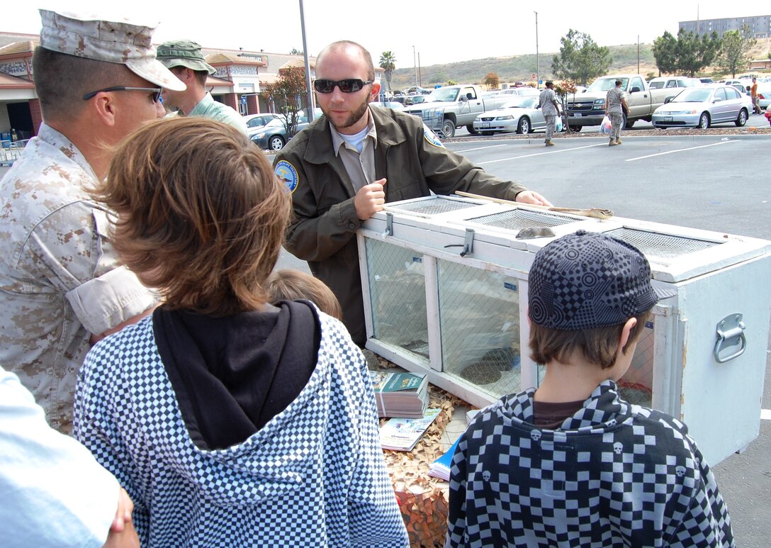 Kevin A. Collins, a federal wildlife technician, explains different species of snakes to Lt. Col. Todd A. Kerzie and his sons during the Earth Day celebration April 22 aboard Camp Pendleton.