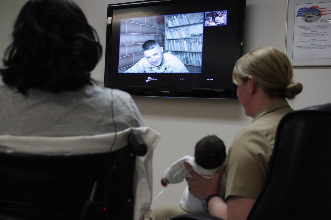 Sgt. John Henry, a squad leader with Company C, 1st Battalion, 7th Marine Regiment, sees his newborn daughter Kelsi for the first time via Freedom Calls Foundation teleconference at the Robert E. Bush Naval Hospital April 23. Henry and the rest of 1/7 are currently deployed to Camp Baharia, Iraq.