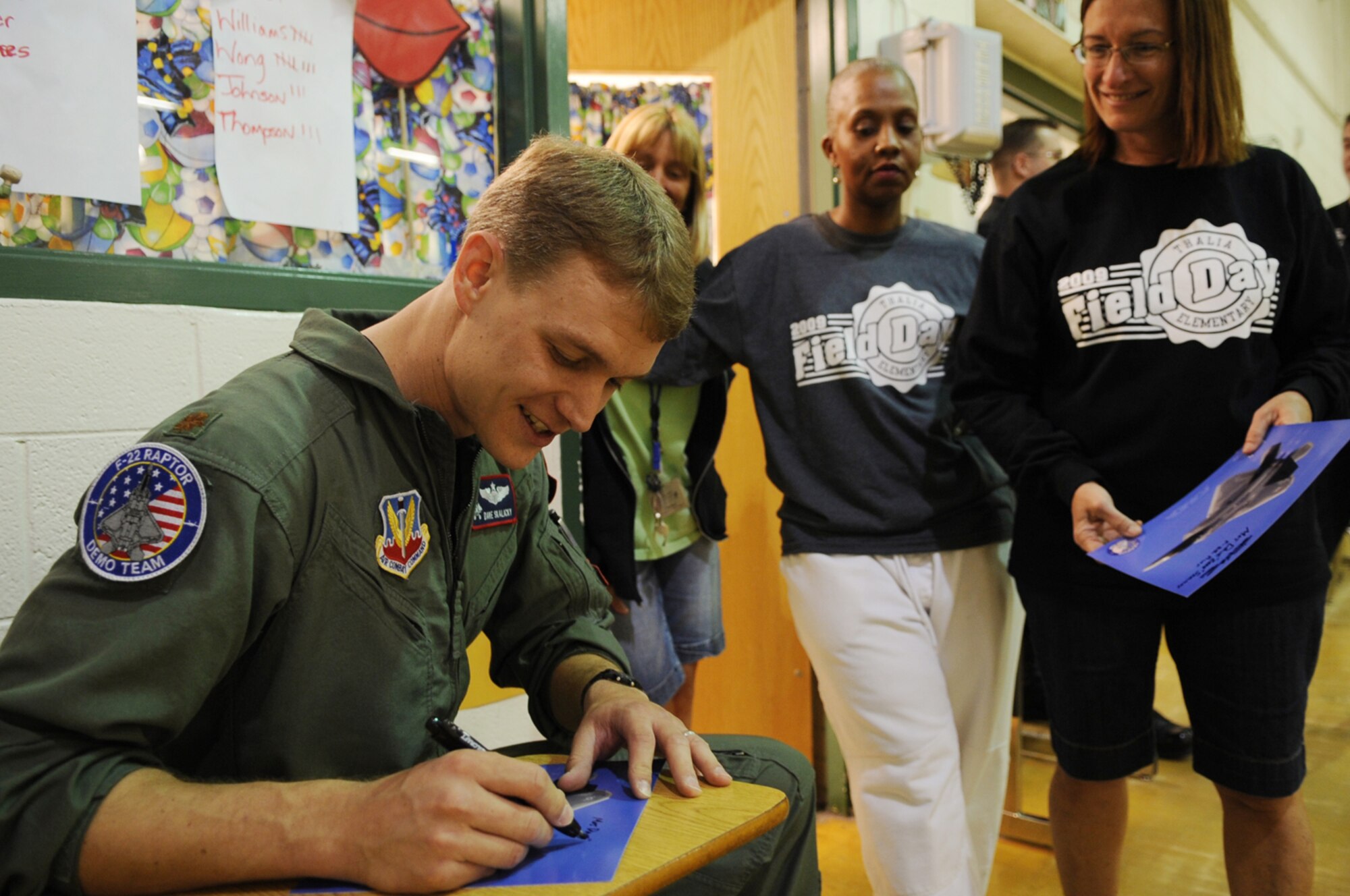 LANGLEY AIR FORCE BASE, Va. -- Maj. Dave "Zeke" Skalicky, F-22A Raptor Demonstration Team pilot, signs an autograph for Irene Cashwell, Thalia Elementary School teacher during his visit to the school for Hampton Roads Air Force Week April 22.  The F-22 Demonstration Team visited schools throughout the local community as a part of Hampton Roads Air Force Week activities. This week is a chance to tell their Air Force story, showcase warfighting capabilities and thank the community for their support.  (U.S. Air Force photo/Staff Sgt. Tabitha Kuykendall)