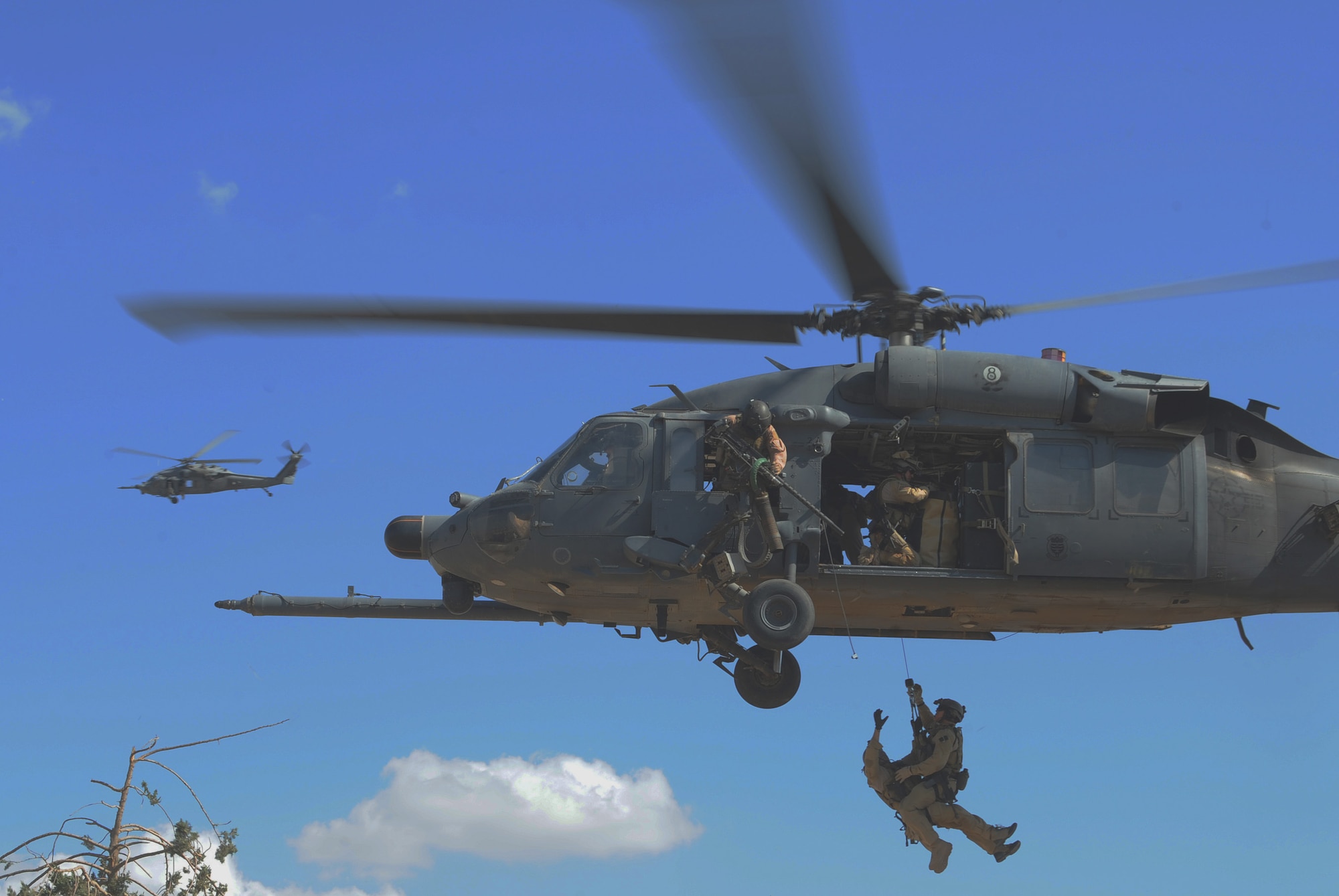 A two-man pararescue team is hoisted to an HH-60 Pave Hawk helicopter in a proficiency exercise April 10 outside of Baghdad, Iraq. They are assigned to the 64th Expeditionary Rescue Squadron at Joint Base Balad, Iraq.  (U.S. Air Force photo/Staff Sgt. James L. Harper Jr.) 