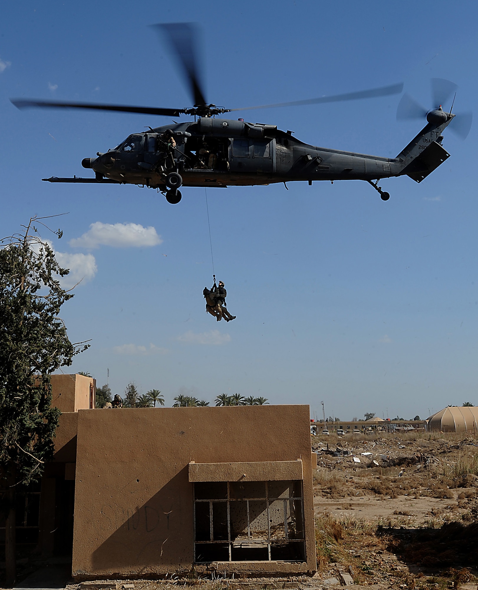 A two-man pararescue team is hoisted to an HH-60 Pave Hawk helicopter in a proficiency exercise April 10 outside of Baghdad, Iraq. They are assigned to the 64th Expeditionary Rescue Squadron at Joint Base Balad, Iraq.  (U.S. Air Force photo/Staff Sgt. James L. Harper Jr.) 