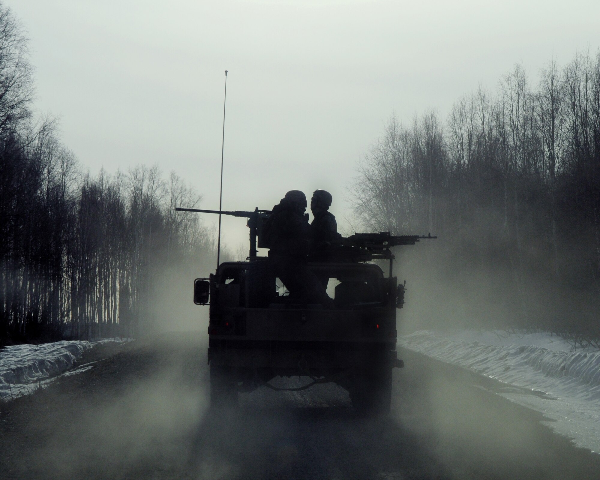 Two Army Special Forces members from the 1st Special Forces Group-Alpha, protect the rear of a convoy on April 22, 2009, Eielson Air Force Base, Alaska. Special Forces were transported to a proposed simulated rescue site in a convoy of humvee?s during a Red-Flag Alaska 09-2 training exercise. (U.S. Air Force photo/Airman 1st Class Willard E. Grande II)
