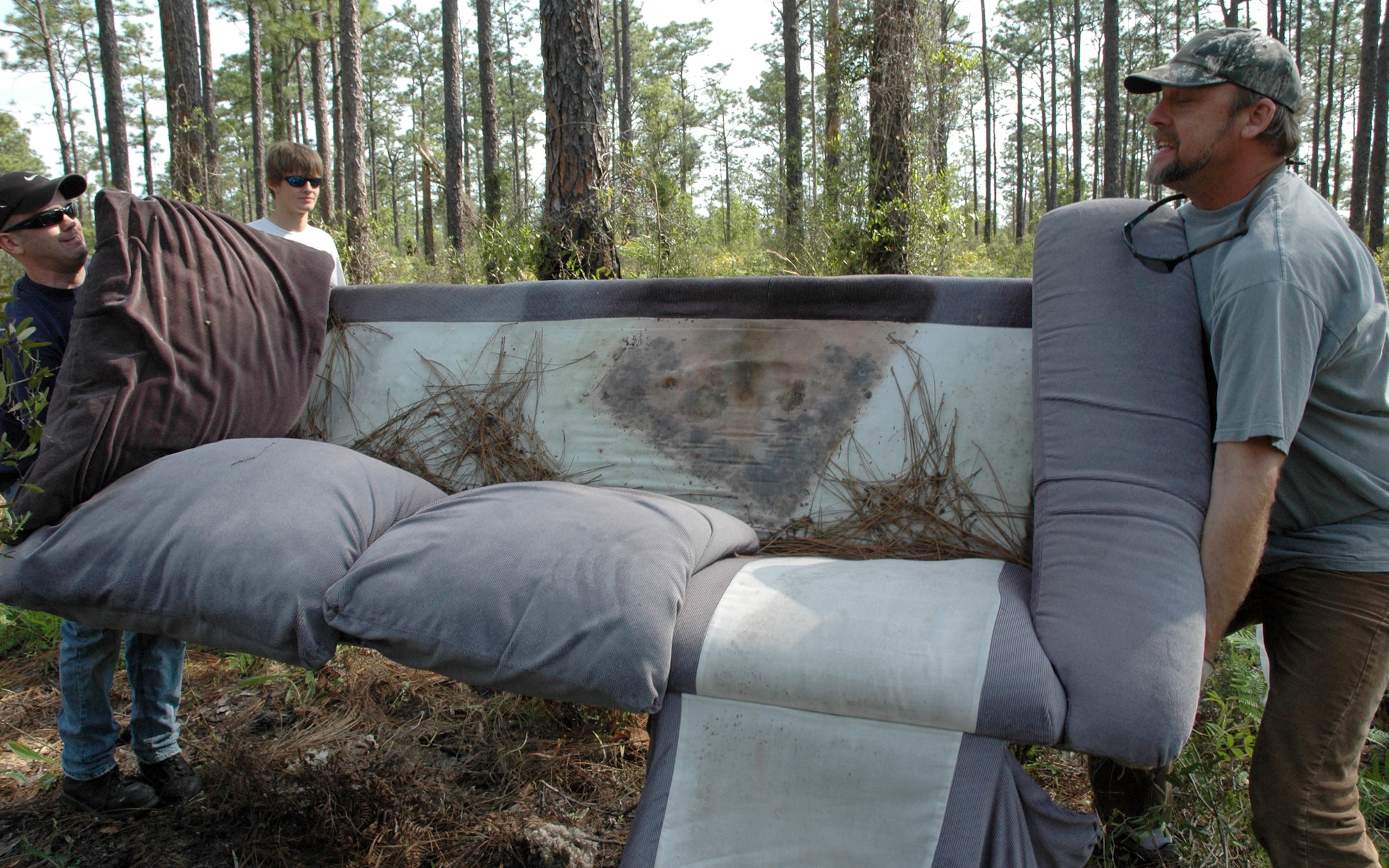 EGLIN AIR FORCE BASE, Fla. -- (left to right) Coast Guard Lt. j.g. Mark Bruno, Thomas Elliot and David Brooks remove sofas discarded in the Eglin Reservation during the Eglin Earth Day clean up April 18 in honor of Earth Week. More than four tons of trash was found at the cite including mattresses, dish washers, recliners, ply wood, roof shingles, privacy fence, carpet, tires, refrigerators and microwaves, just to name a few. The piles of trash were picked up the next day. Most of the volunteers for this project are members of local off-road and four-wheel drive clubs. (U.S. Air Force photo/ Airman Anthony Jennings)