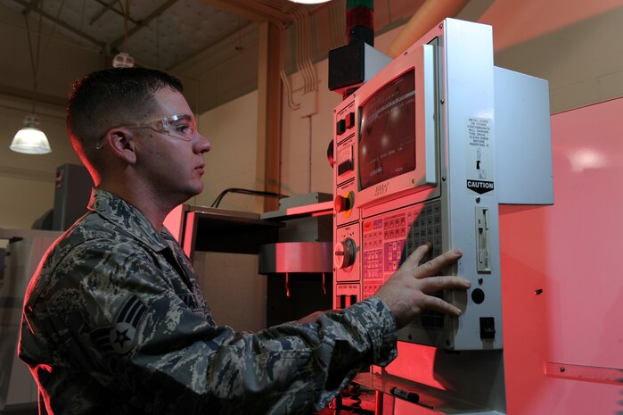Senior Airman Chad Mattingly, a metals technician with the 57th Component Maintenance Squadron, programs a layout design into the computer numerical control (CNC), April 16, Nellis Air Force Base, Nev. The 57th CMS uses machines like the CNC to make structural repairs to components for various aircraft.(U.S. Air Force photo by/Senior Airman Nadine Y. Barclay/RELEASED)