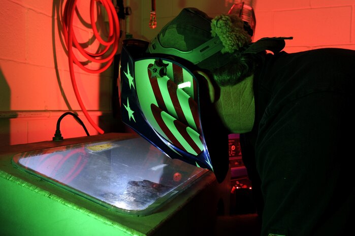 Mr. Randy Cherland, a metals technician with the 57th Components Maintenance Squadron, uses a purge chamber to weld a jet engine augmenter nozzle support, April 16, Nellis Air Force Base, Nev. The 57th CMS is responsible for the structural maintenance of all aircraft assigned to the 57th Wing. (U.S. Air Force photo by/Senior Airman Nadine Y. Barclay/RELEASED)