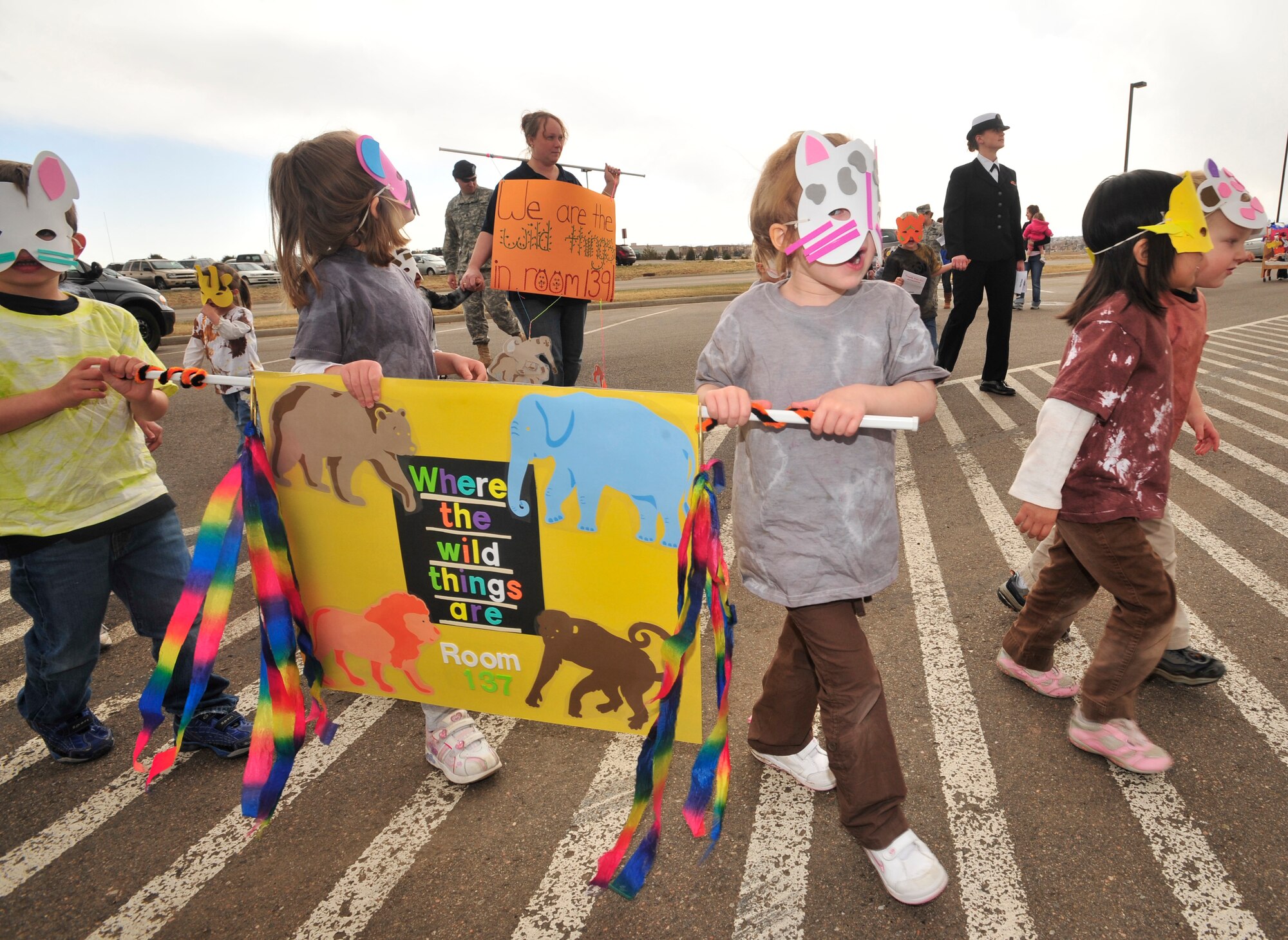 BUCKLEY AIR FORCE BASE, Colo. -- Children, parents and staff from both Child Development Centers participated in the kickoff parade for the Month of the Military Child here, April 3.  Many of the children dressed up in masks and face paint to walk in the parade.  The month of April is dedicated to the more than $1.7 million American children under the age of 18 that have at least one parent serving in the military.  (U.S. Air Force photo by Senior Airman Alex Gochnour)