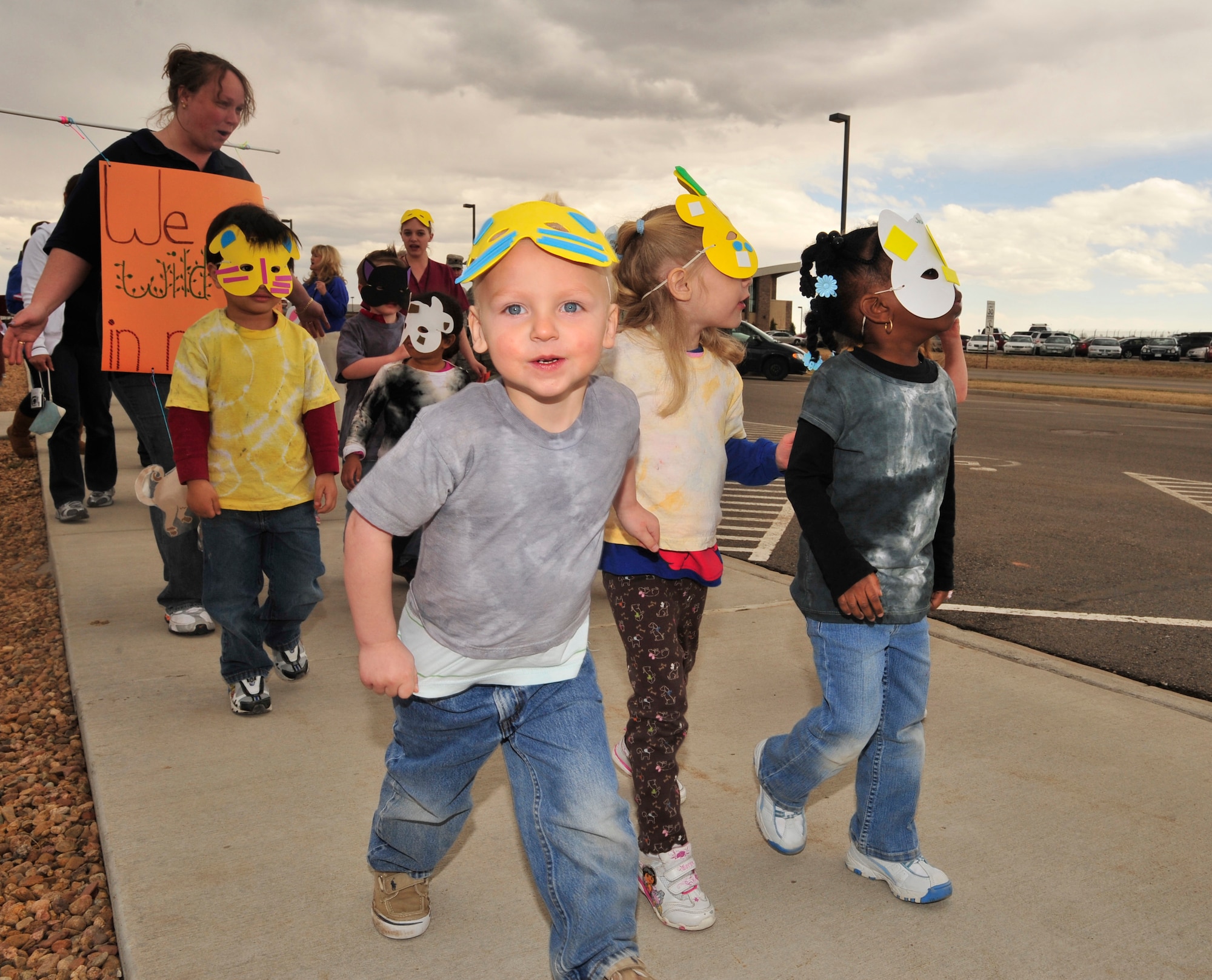 BUCKLEY AIR FORCE BASE, Colo. -- Children from the A Basin Child Development Center march in a parade to kickoff the Month of the Military Child here, April 3.  Children, parents and staff from both CDCs participated in the event.  Many of the children dressed up in masks, face paint and carried flags and streamers to walk in the parade.  The month of April is dedicated to the more than 1.7 million American children under the age of 18 that have at least one parent serving in the military.  (U.S. Air Force photo by Senior Airman Alex Gochnour)
