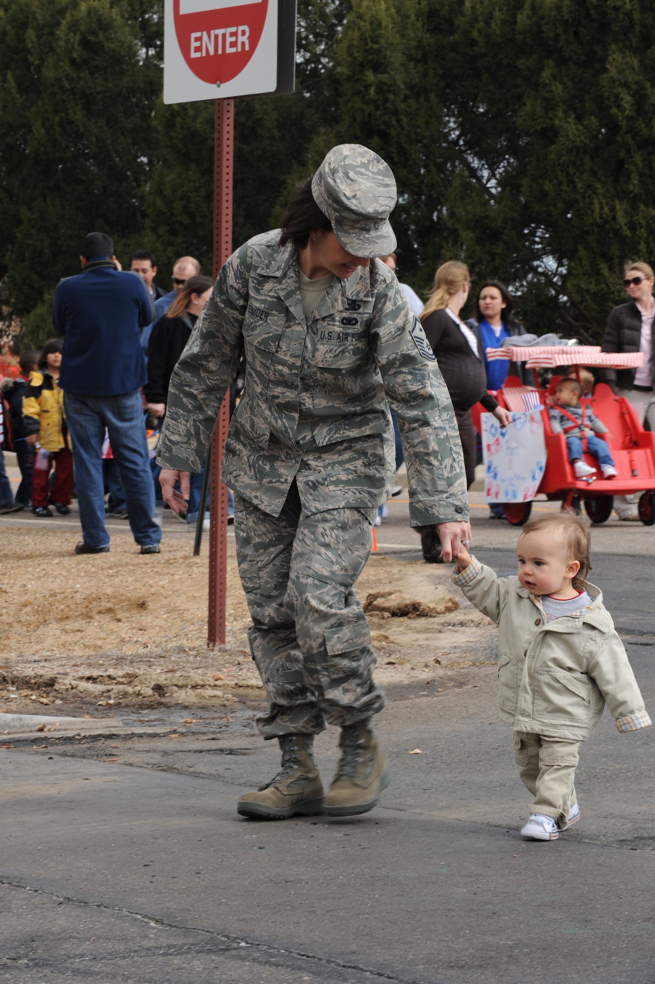 BUCKLEY AIR FORCE BASE, Colo. -- Master Sgt. Deanna Snider, 460th Mission Support Group first sergeant, holds the hand of her son, Avery, during a parade to kickoff the Month of the Military Child here, April 3.  Children, parents and staff from both CDCs participated in the event.  The month of April is dedicated to the more than 1.7 million American children under the age of 18 that have at least one parent serving in the military.  (U.S. Air Force photo by Senior Airman John Easterling)