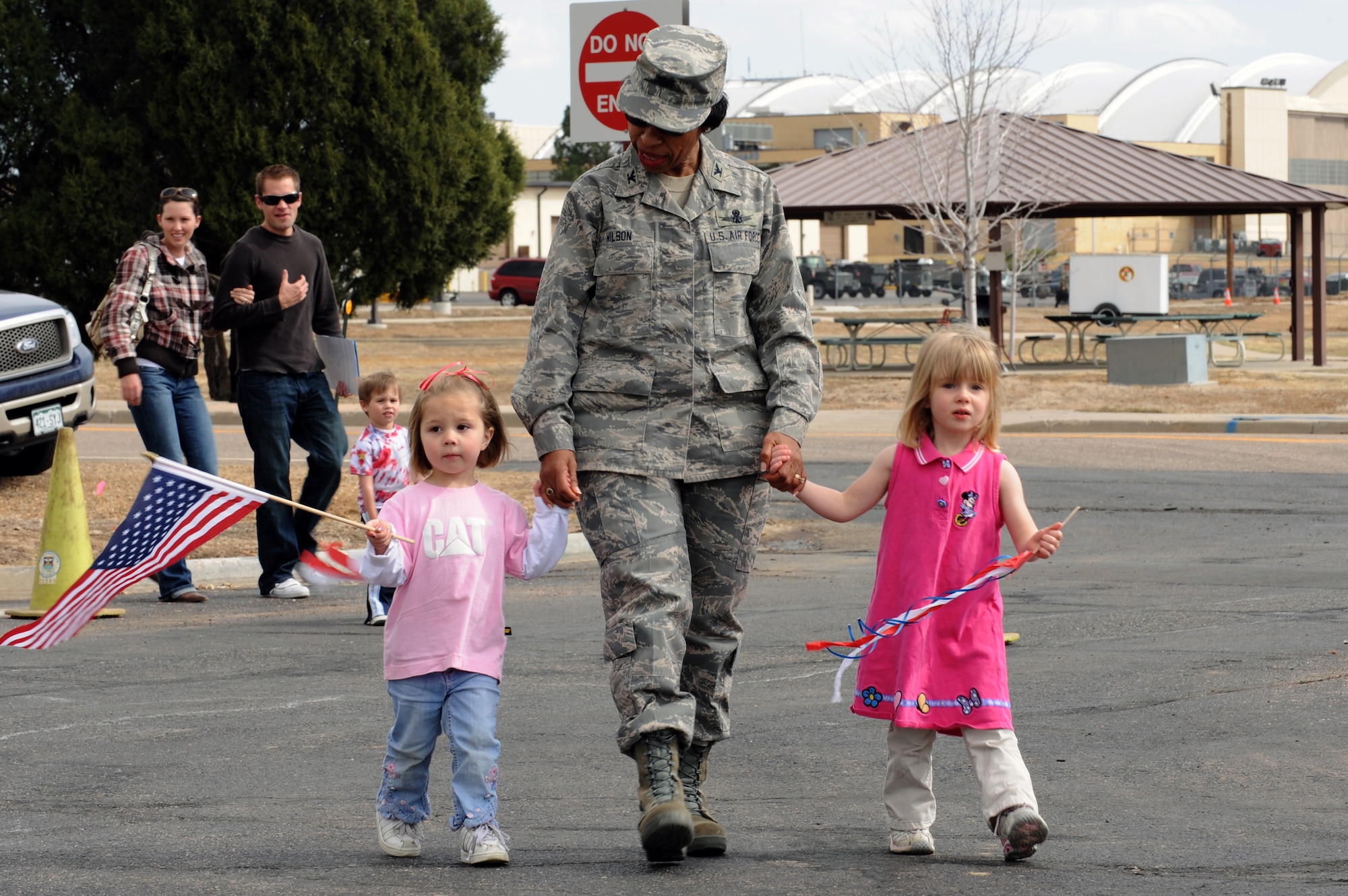 BUCKLEY AIR FORCE BASE, Colo. -- Colonel Charlotte Wilson, 460th Space Wing Vice Commander, holds the hands of two children from the Crested Butte Child Development Center during a parade to kickoff the Month of the Military Child here, April 3.  Children, parents and staff from both CDCs participated in the event.  Many of the children dressed up in masks, face paint and carried flags and streamers to walk in the parade.  The month of April is dedicated to the more than 1.7 million American children under the age of 18 that have at least one parent serving in the military.  (U.S. Air Force photo by Senior Airman John Easterling)
