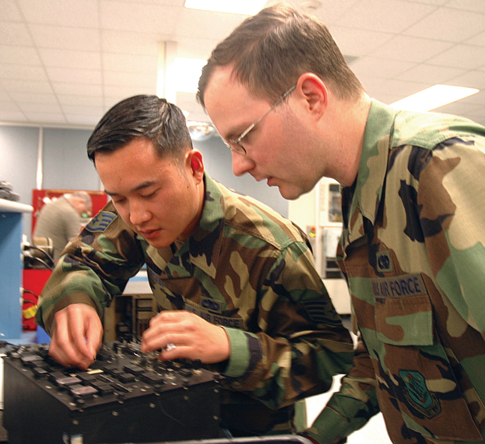 Staff Sgt. Christopher Parcasio, left, shows Senior Airman Buell Richardson how to repair a fuel-system, engine-start control panel. Both reservists are assigned to the 446th Maintenance Squadron, McChord Air Force Base, Wash. (U.S. Air Force photo/Tech. Sgt. Jake Chappelle)