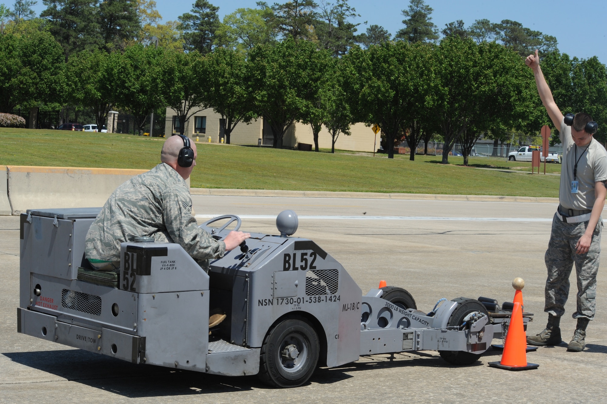 Senior Airman Tyrell Velasquez (right) signals Senior Airman Frederick Manternach as they demonstrate precision driving of an MJ-1 weapons loader during a load crew competition at Seymour Johnson Air Force Base, N.C., April 17, 2009. As part of the weapons loader obstacle course, Airman Manternach contacted a cone without knocking off a softball that sat upon it in which he earned first place in the driving portion of the competition. Both Airmen are members of the 4th Aircraft Maintenance Squadron. (U.S. Air Force photo by Airman 1st Class Whitney S. Lambert)