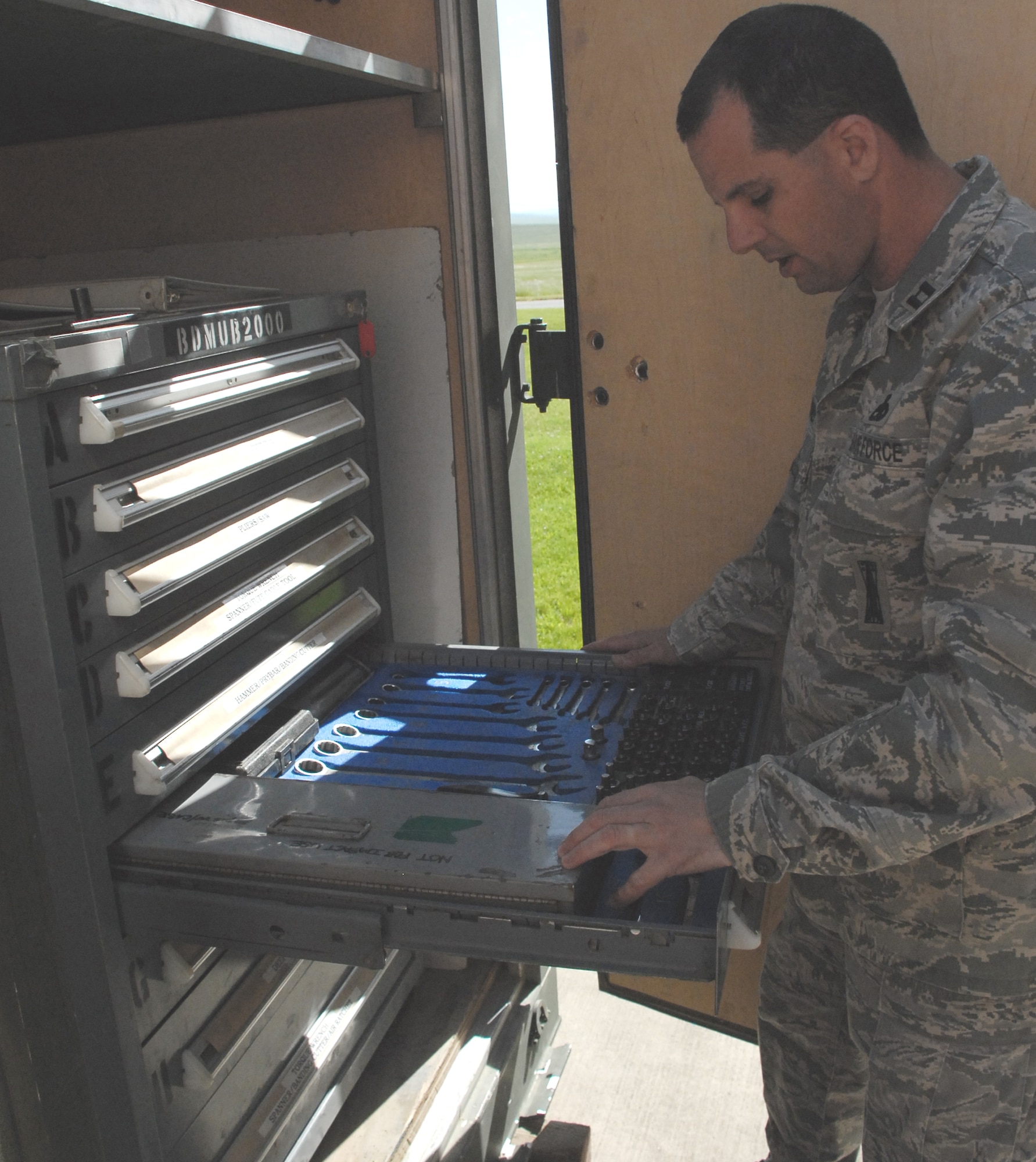 Capt. Mathew Drossner searches for tools during a AFSO-21 event April 3. The serviceable process was established as part of a Rapid Improvement Event held last week to assist the 9th MUNS in maximizing value and minimizing waste. Captain Drossner is assigned to the 9th Munitions Squadron. (U.S. Air Force photo/Ashley Cisek) 