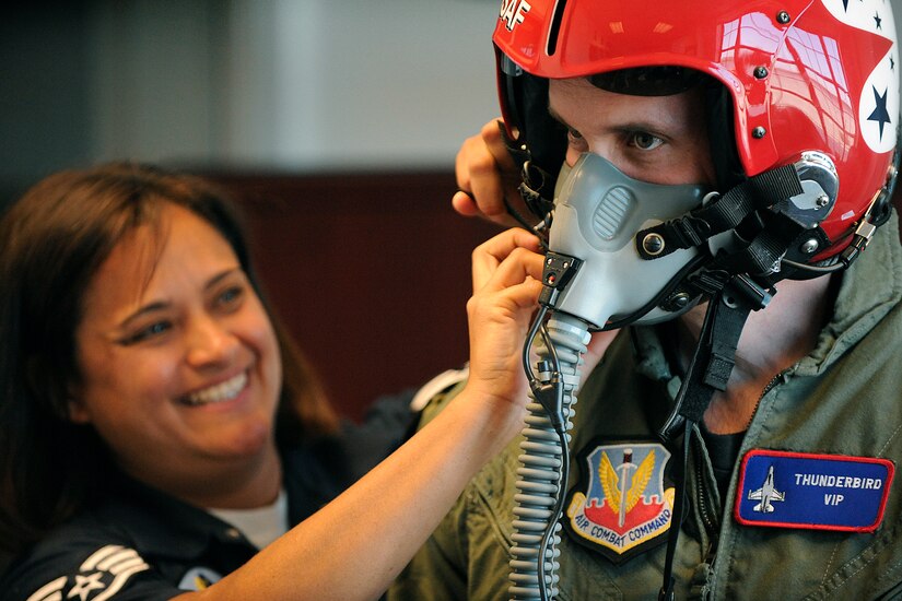 LANGLEY AIR FORCE BASE, Va. -- Staff Sgt. Robbin Bailon, Thunderbirds flight equipment technician, adjusts a helmet while fitting Trooper Kurt Johnson, Virginia State Police, for his flight suit here April 23.  Trooper Johnson was awarded a hometown hero certificate along with a flight for saving a little girl from a burning car on her third birthday.  "I didn't even think, if it were one of my sons, I would've done the same thing," said Trooper Johnson.  (U.S. Air Force photo/Senior Airman Vernon Young)