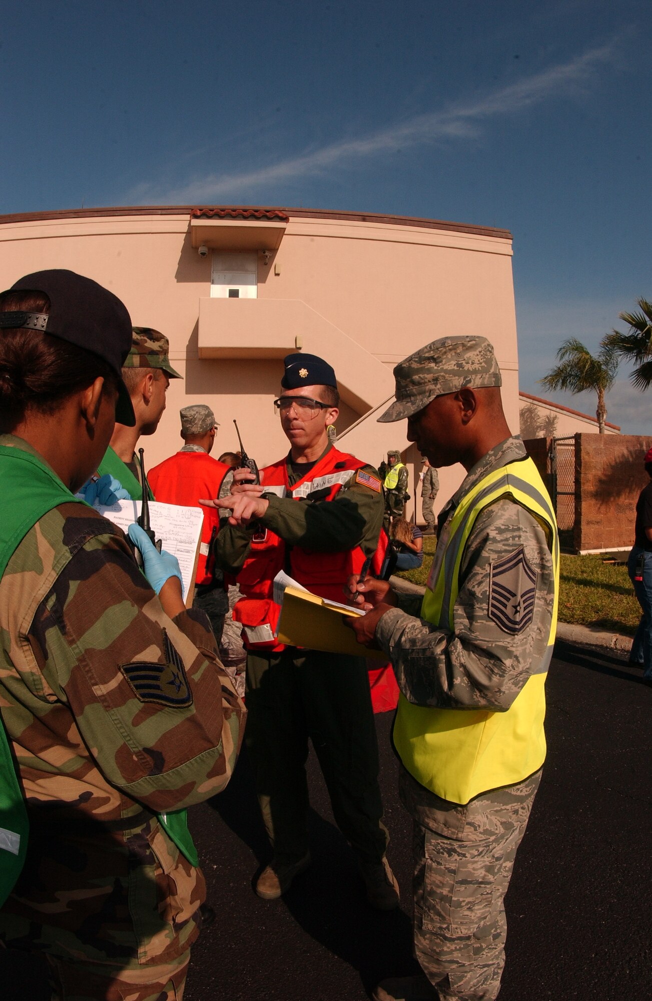 Senior Master Sgt. James Green, an Exercise Evaluation Team member, evaluates the patient accountability process of the Immediate Medical Response Team during a simulated hazardous vehicle incident at the Base Clinic April 17, while Maj. (Dr.) Michael Maine, IMRT team chief (center) injects guidance and information to his team members. (U.S. Air Force photo/Master Sgt. Robert Burgess)