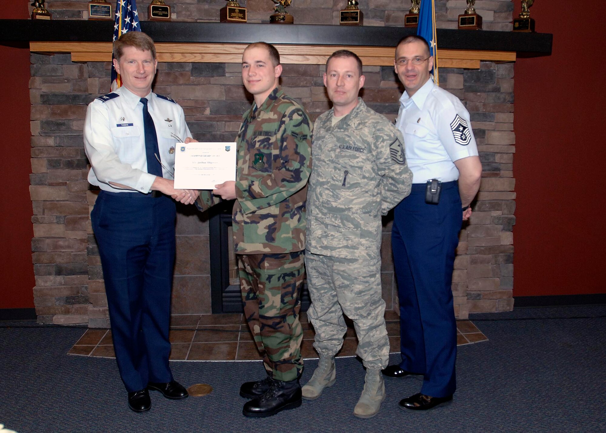 Col. Robert Thomas, 92nd Air Refueling Wing commander, and Chief Master Sgt. David Nordel, 92nd Air Refueling Wing command chief, present Airman 1st Class Joshua Shipman, 22nd Training Squadron Survival Evasion, Resistance and Escape specialist, with the Diamond Sharp Award at the Warrior Dinning Facility, April 14. Airman Shipman was nominated by Master Sgt. Robert Myers, 22nd TRS first sergeant, for his outstanding work performance and professionalism. (U.S. Air Force photo / Airman 1st Class Melissa L. Carlino)