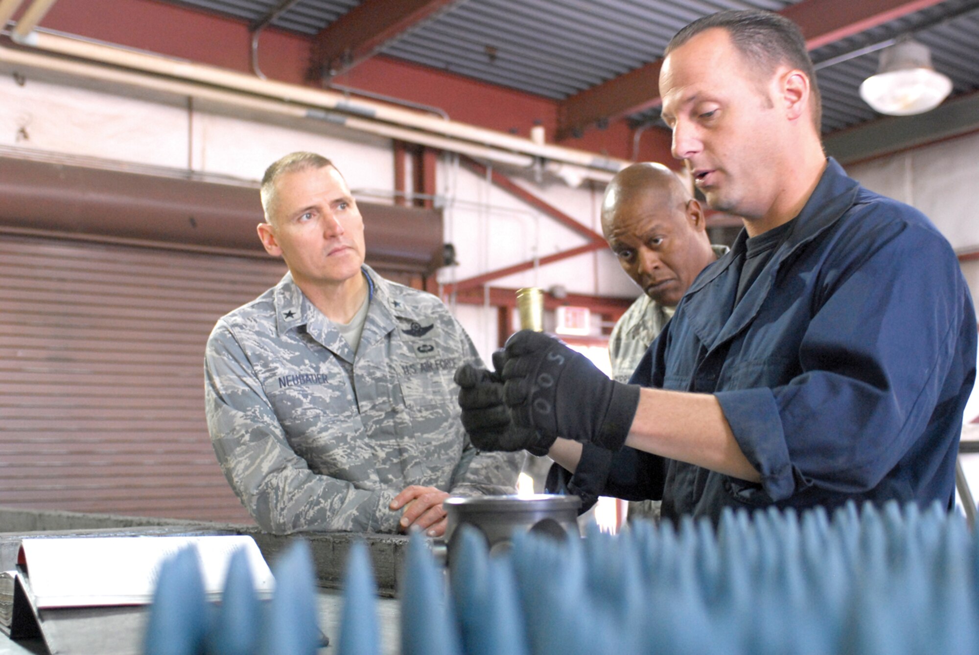 Staff Sgt. Timothy Alley, 56th Equipment Maintenance Squadron munitions systems crew chief, explains the process involved in performing a visual inspection on a 20mm round to Brig. Gen. Kurt Neubauer, 56th Fighter Wing commander, and Col. Andre Curry, 56th Mission Support Group commander, during their tour of the EMS munitions storage area, April 16. (U.S. Air Force photo/Airman 1st Class Tracie Forte)