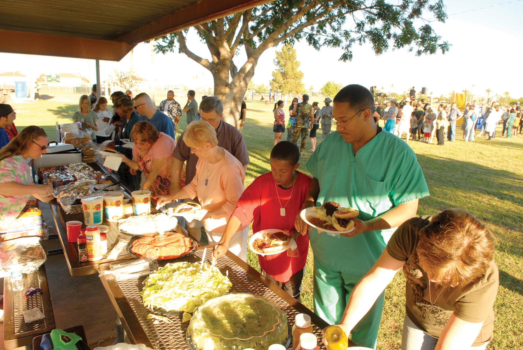 Friends and family of the 56th Medical Group load their plates at the buffet during the 56th MDG MASH Bash held at Fowler Park Saturday. Hamburgers, chips, potato salad and beans were served. (U.S. Air Force photo/Airman 1st Class Ronifel Yasay)