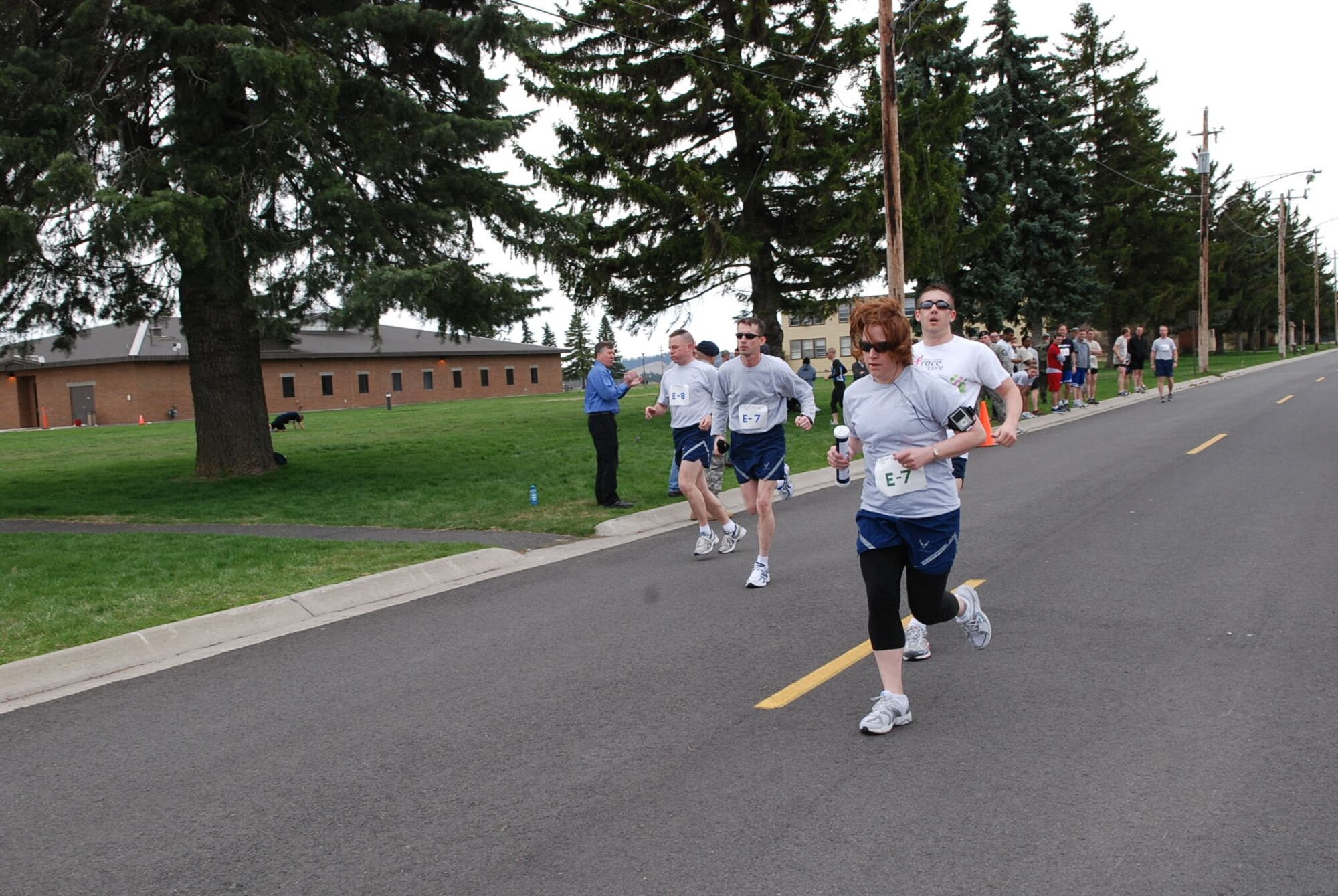 Members of the Medical Group team pass their baton in the middle of the race. Their baton was an oversized prescription bottle. (U.S. Air Force photo/Senior Airman Emerald Ralston) 