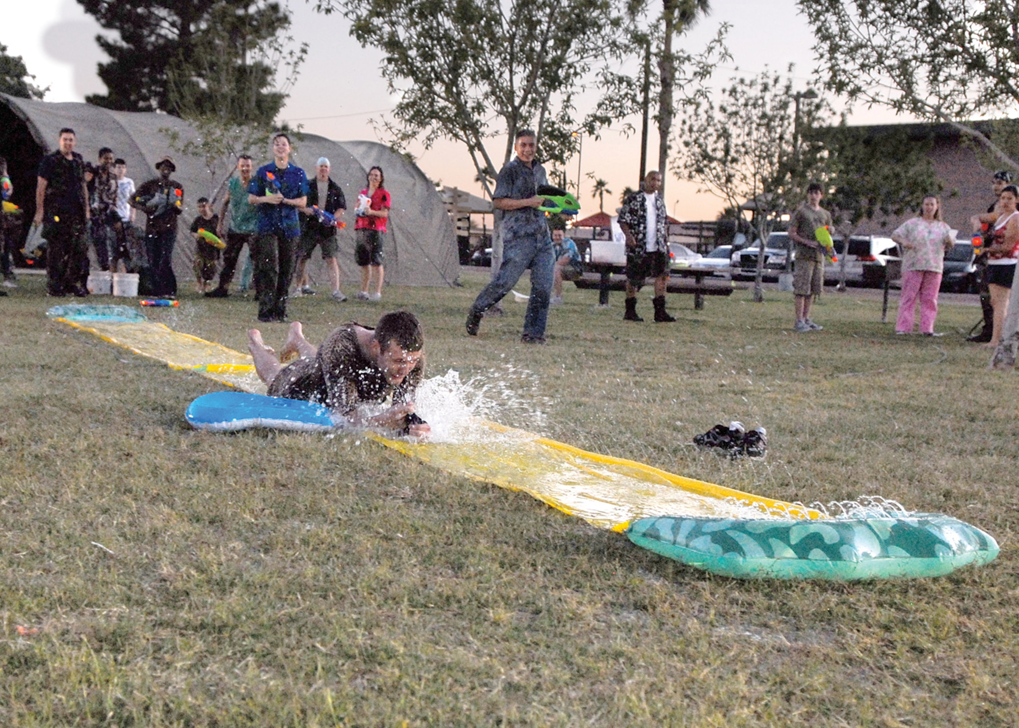 Airman 1st Class Aaron Youngblood, 56th Medical Operations Squadron physical therapist technician, slides across the slip-and-slide during the 56th Medical Group MASH Bash held at Fowler Park Saturday. (U.S. Air Force photo/Airman 1st Class Ronifel Yasay)