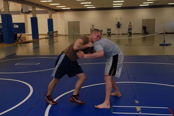 Senior Airman Eddie Fore and Senior Airman Jacob Chambers, both Survival, Evasion, Resistance and Escape water survival instructors, practice wrestling techniques at the base gym. Airman Fore recently returned from competing with the Air Force wrestling team. (U.S. Air Force photo/Senior Airman Emerald Ralston)