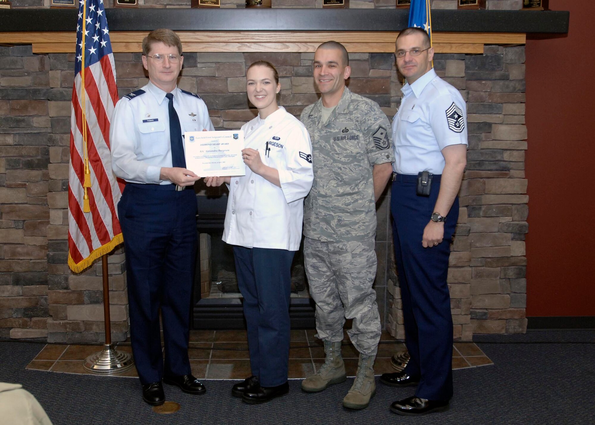 Col. Robert Thomas, 92nd Air Refueling Wing commander, and Chief Master Sgt. David Nordel, 92nd Air Refueling Wing command chief, award Airman 1st Class Alexandra Burgeson, 92nd Force Support Squadron first cook, with the Diamond Sharp award at the Warrior Dining Facility, April 14. Master Sgt. Christopher Leo, 92nd Aircraft Maintenance Group first sergeant, nominated Airman Burgeson for epitomizing the three Air Force core values: Integrity First, Service before Self and Excellence in all we do. (U.S. Air Force photo / Airman 1st Class Melissa L. Carlino)