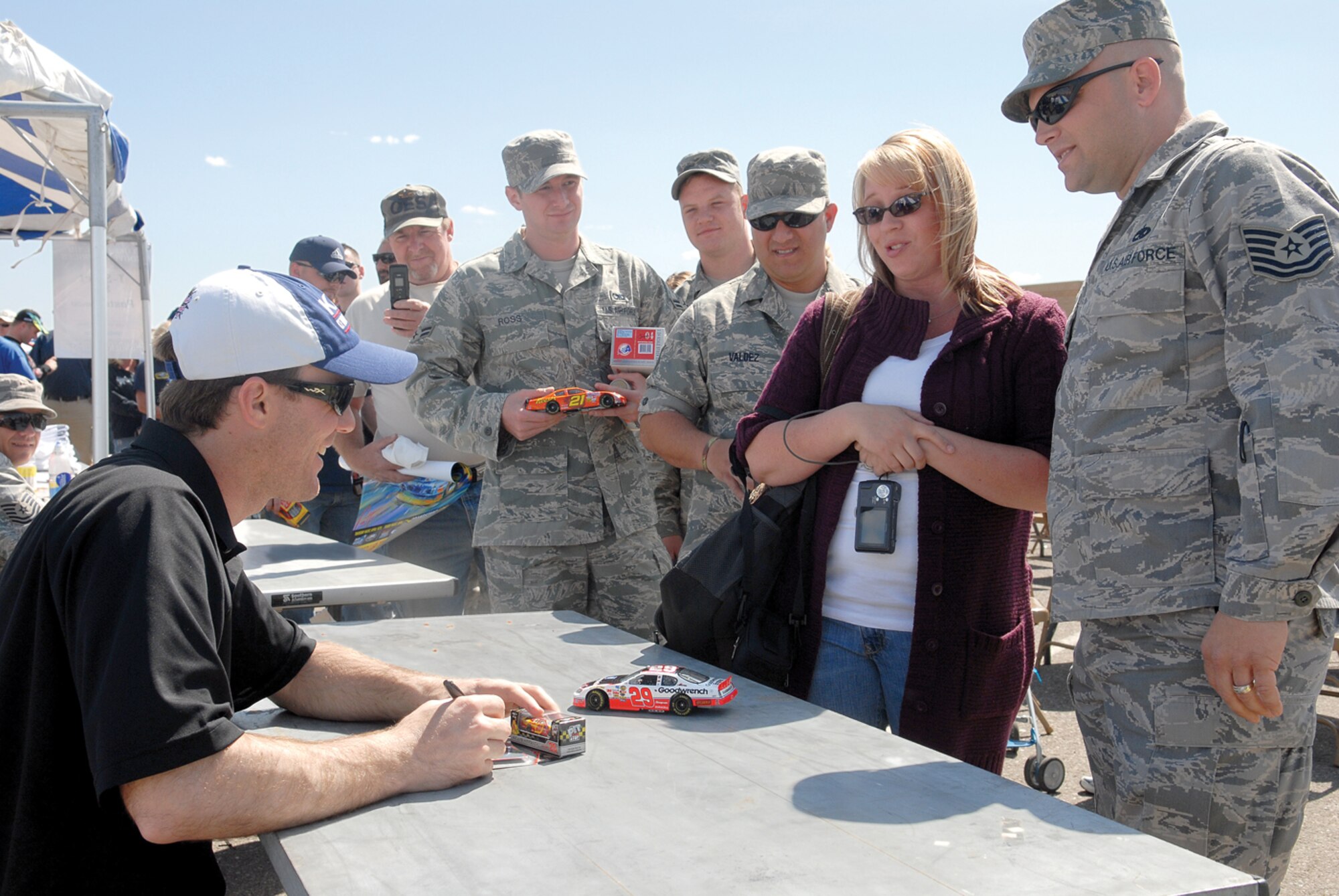 Carmen Henshaw and Tech. Sgt. Vernon Henshaw, 56th Maintenance Operations Squadron quality assurance inspector, have NASCAR driver Kevin Harvick, car No. 29, sign memorabilia.(U.S. Air Force photo/ Deborah Silliman Wolfe)