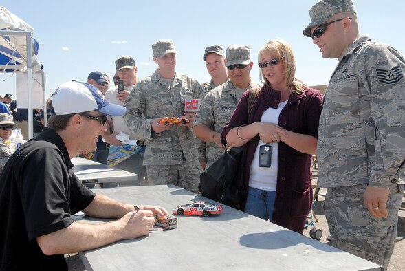 Carmen Henshaw and Tech. Sgt. Vernon Henshaw, 56th Maintenance Operations Squadron quality assurance inspector, have NASCAR driver Kevin Harvick, car No. 29, sign memorabilia.(U.S. Air Force photo/ Deborah Silliman Wolfe)