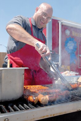 Brian Piersee, kitchen manager at Famous Dave’s, grills up sausage links during a Salute to Military Families NASCAR ticket giveaway April 16 at Luke Air Force Base. (U.S. Air Force photo/ Deborah Silliman Wolfe)