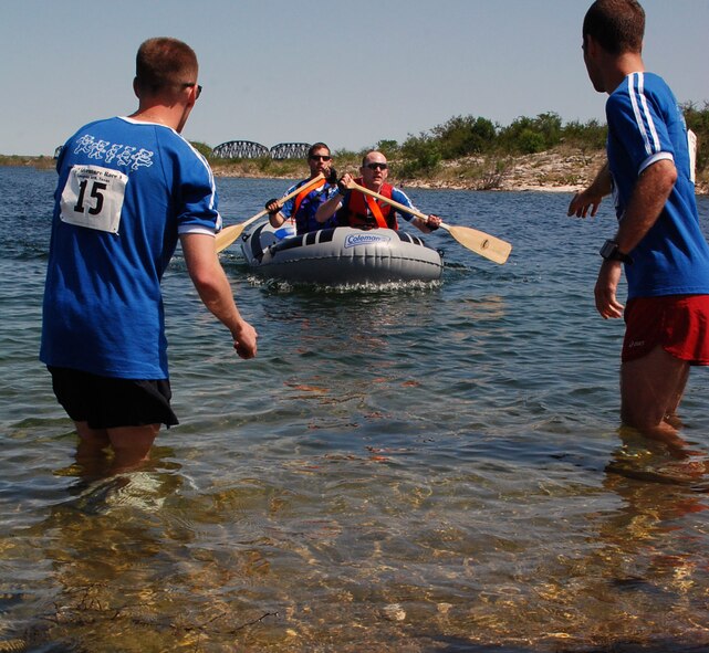 LAUGHLIN AIR FORCE BASE, Texas – Two members of the winning team, The Rio Lobos Project from the 86th Flying Training Squadron, reach for their other team members to switch out rafters and race to the finish line during the 2-mile rafting portion of the 35-mile Adventure Race V held here April 18. (U.S. Air Force photo by Airman 1st Class Sara Csurilla)