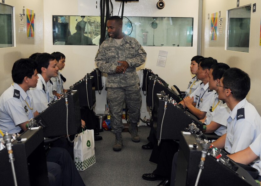 Master Sgt. Charles Acron gives a briefing on the altitude chamber to visiting enlisted Japan Air Self Defense Force members April 15 as part of the bilateral exchange program on Kadena Air Base.  Sergeant Acron is the physiology flight chief for the 18th Aerospace Medical Squadron. (U.S. Air Force photo/Staff Sgt. Angelique Perez )