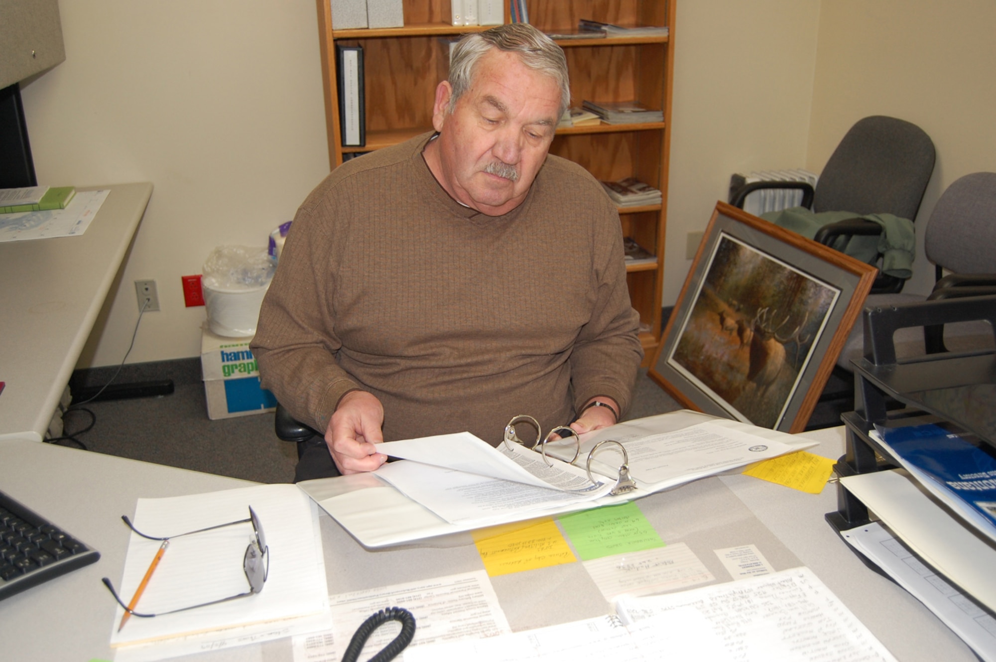 Milt Feltch, president of the Montana Retiree's Council, looks over some new guidance in the council's office at the Malmstrom Clinic. Mr. Feltch, who is also a retired colonel, has been active with the council for three years and continues to serve because he likes to help the retirees. April 19-26 is National Volunteer Recognition Week. (U.S. Air Force photo/Valerie Mullett)