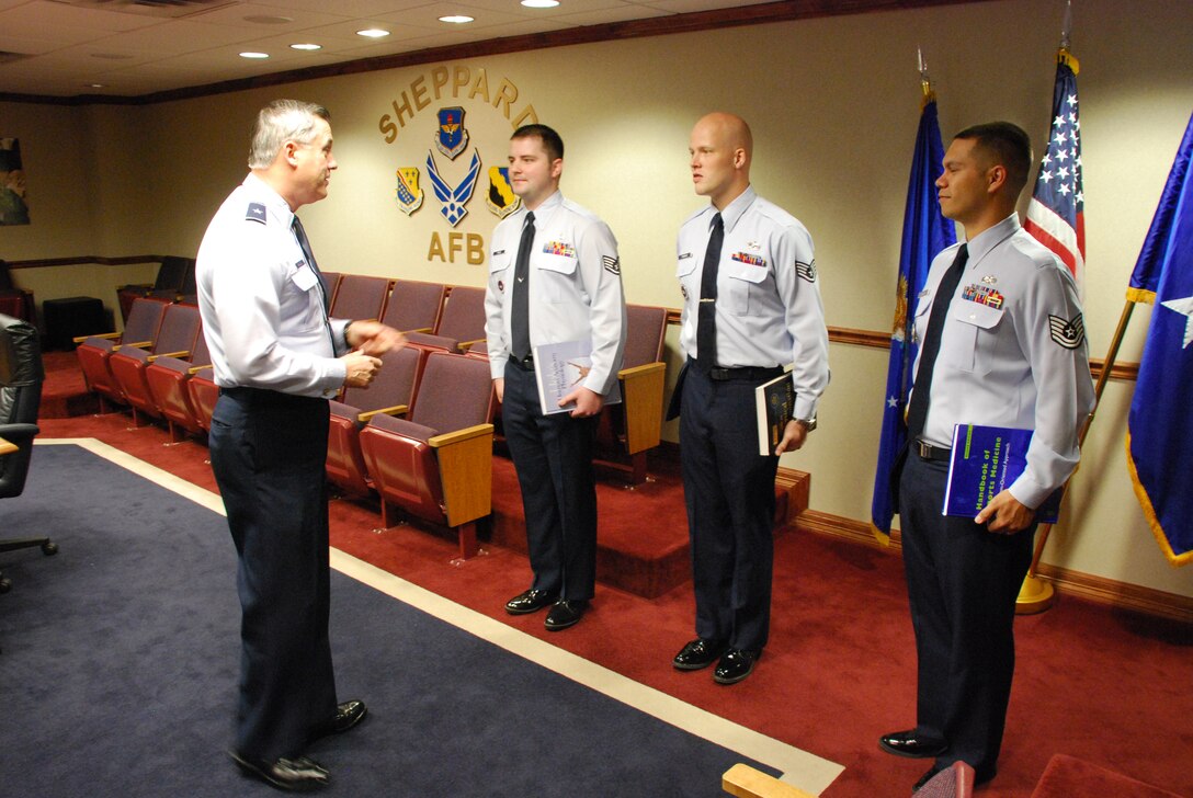 Brig. Gen. O.G. Mannon, 82nd Training Wing commander, congratulates Airmen on their acceptance into the Physician’s Assistant Training program April 24 in the 82nd TRW conference room. From left to right, Staff Sgt. Jared Files, 383rd Training Squadron, Staff Sgt. William Rannow, 365th TRS, and Tech. Sgt. Christopher Wilbur, 365th TRS, were given their new text books and coined by General Mannon for their achievement.