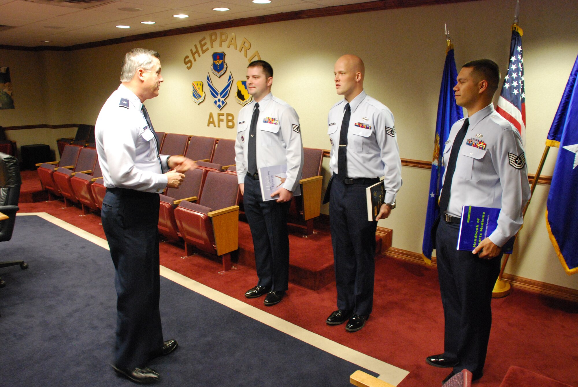 Brig. Gen. O.G. Mannon, 82nd Training Wing commander, congratulates Airmen on their acceptance into the Physician’s Assistant Training program April 24 in the 82nd TRW conference room. From left to right, Staff Sgt. Jared Files, 383rd Training Squadron, Staff Sgt. William Rannow, 365th TRS, and Tech. Sgt. Christopher Wilbur, 365th TRS, were given their new text books and coined by General Mannon for their achievement.