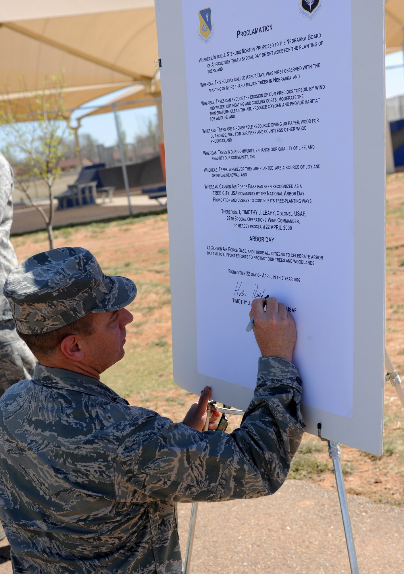 CANNON AIR FORCE BASE, N.M. -- Col. Ruedi Kaspar, 27th Special Operations Wing vice commander, signs the Arbor Day Proclamation at Doc Stewart Park here April 22. The Arbor Day Foundation named Cannon as a 2009 Tree City USA community and presented Cannon with its first Growth Award for the base's local environmental improvement efforts. The  27th Special Operations Civil Engineer Squadron Natural Resources Management Flight hosted numerous Arbor Day observances that included a storytelling session with kids at the Ranchvale Child Development Center on April 23.  (U.S. Air Force Photo/Airman 1st Class Evelyn Chavez)